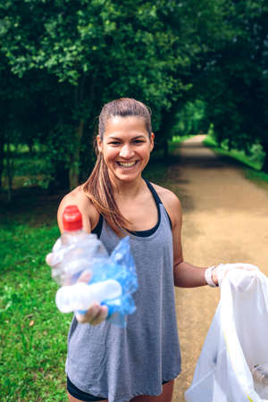 Girl showing the garbage she has collected. Selective focus on girl in backgroundの写真素材