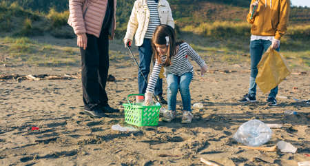 Little girl with group of volunteers preparing to clean the beachの写真素材