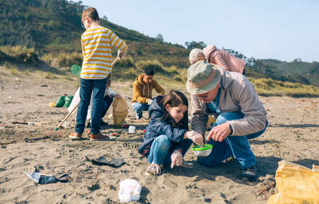 Group of volunteers picking up trash on the beach