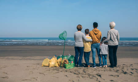 Group of volunteers backwards watching the sea after cleaning the beach