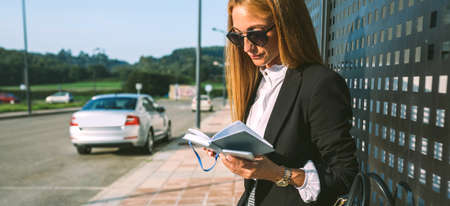 Businesswoman working in the street reading diaryの写真素材