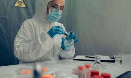 Female scientist analyzing samples contaminated with virus in a laboratoryの写真素材