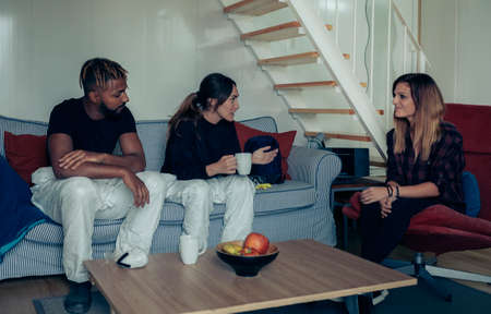 Woman talking with two people in bacteriological protection suit who ask for her collaborationの写真素材