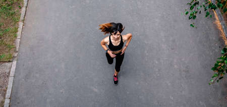Aerial view of female athlete running on a roadの写真素材
