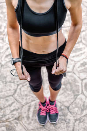 Unrecognizable athlete woman posing with skipping rope in a parkの写真素材