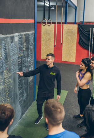 Coach explaining to a group of athletes in the gymの写真素材