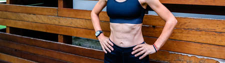 Female athlete posing in front of a wooden background