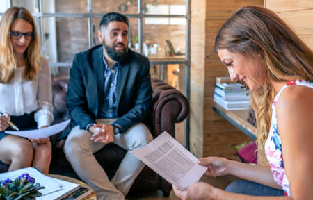Business people having an informal work meeting sitting on the couch. Selective focus on woman in...