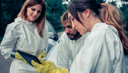 Group of experts in bacteriological protection suits planning virus fight