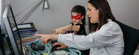 Woman teleworking with daughter talking to her. Selective focus on girl in background