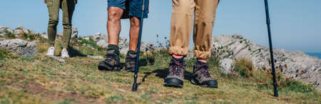 Group of three people practicing trekking outdoors. Selective focus on man in background