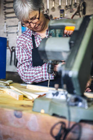 Senior woman working in a carpentry workshopの写真素材