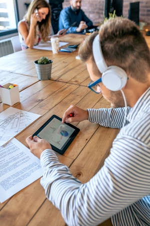 Young businessman working in a coworking office with his colleaguesの写真素材