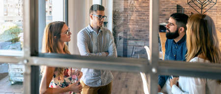 Young people at a business meeting standing in the office