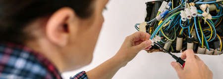 Unrecognizable female electrician working on the electrical installation of a houseの写真素材