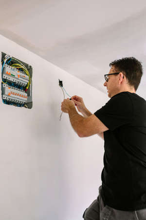Male electrician working on the electrical installation of a house
