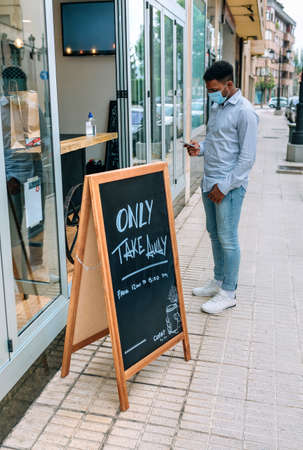 Young man with mask waiting to buy take away foodの写真素材