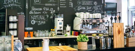 Empty cafe interior with counter, coffee maker and blackboard with menuの写真素材