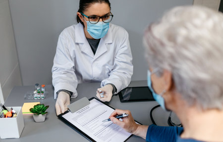 Female doctor explaining to her patient the benefits and risks of the coronavirus vaccineの写真素材