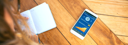 Unrecognizable businesswoman taking notes in her agenda and her mobile with ethereum information