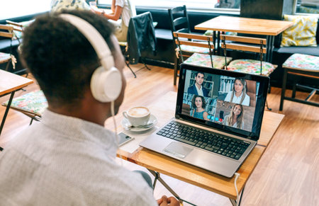 Unrecognizable man working by videoconference from a coffee shop