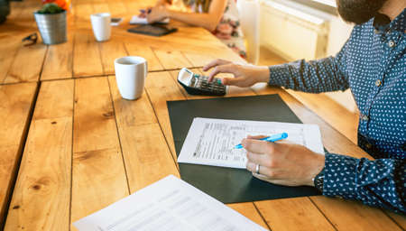 Unrecognizable male adviser filling in tax documents in office