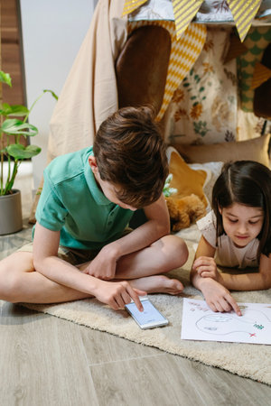 Boy and girl playing treasure hunting game in a tent at home. Staycation concept