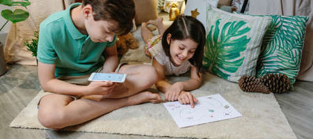 Children playing in a cozy diy tent at home. Staycation concept