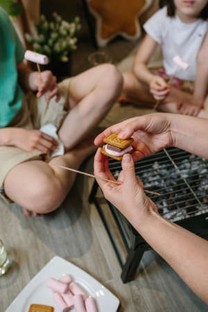 Smore that a family is preparing with a small barbecue at home. Selective focus on smore in foregroundの写真素材