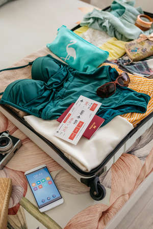 Top view of open woman suitcase prepared for summer vacationの写真素材