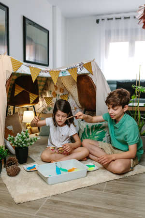 Boy and girl camping at home playing fishing gameの写真素材