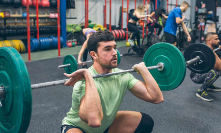 Man practicing weightlifting lifting weights in the gymの写真素材