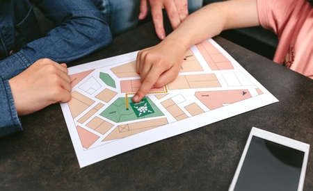 Unrecognizable family looking assembly point map at home