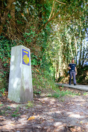 Milestone of Saint James way with pilgrim walking in the backgroundの写真素材
