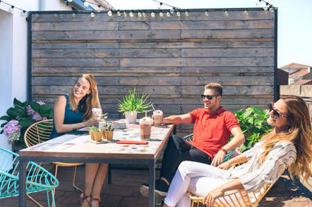 Group of friends having a drink at a party on a terraceの写真素材
