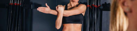 Sportswoman stretching arms in fitness class in the gym