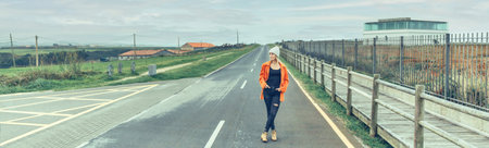 View from inside camper van of young woman posing on the road