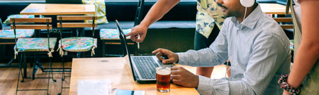 Group of friends having fun on video call with laptop from cafe