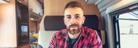 Man looking at camera talking on videoconference from his campervanの写真素材
