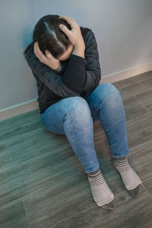 Top view of unrecognizable woman with mental disorder and  thoughts holding her head with her hands
