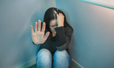 Desperate woman with mental health problems refusing help with hand. Selective focus on hand in...