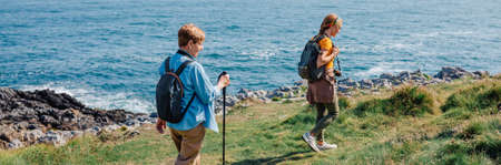 Grandmother and adult granddaughter trekking along the coast togetherの写真素材