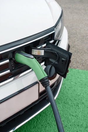 Detail of socket plugged into electric car outdoors