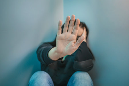 Unrecognizable woman with mental health problems refusing help with hand. Selective focus on hand in foregroundの写真素材