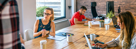 Angry young female manager discussing with man for coming late to office in the morning. Employee punctuality at work concept.の写真素材