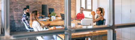 Group of four colleagues searching new ideas in brainstorm while having fun playing with basket ball in a coworking office. Relax and creativity time at office.の写真素材
