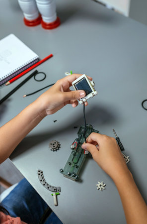 Unrecognizable female student connecting solar panel to electrical circuit in a robotics class. Elementary technological education concept.の写真素材