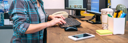 Unrecognizable woman checking orders received by ecommerce shop. Banner of woman wearing a plaid...
