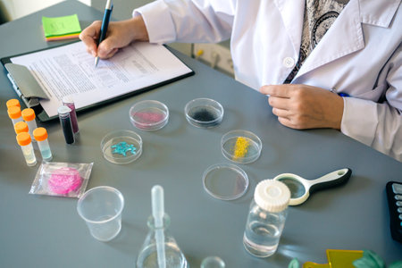 Unrecognizable female scientist examining glitter samples in petri dishes on a pharmaceutical...