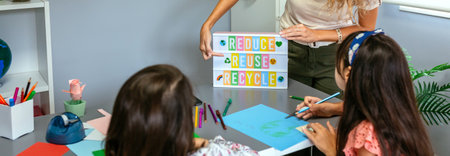 Unrecognizable female teacher explaining to students in classroom how it is a ecologic process while...